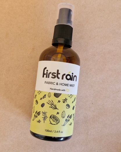 Bottle of 'first rain' fabric & home mist on a beige background