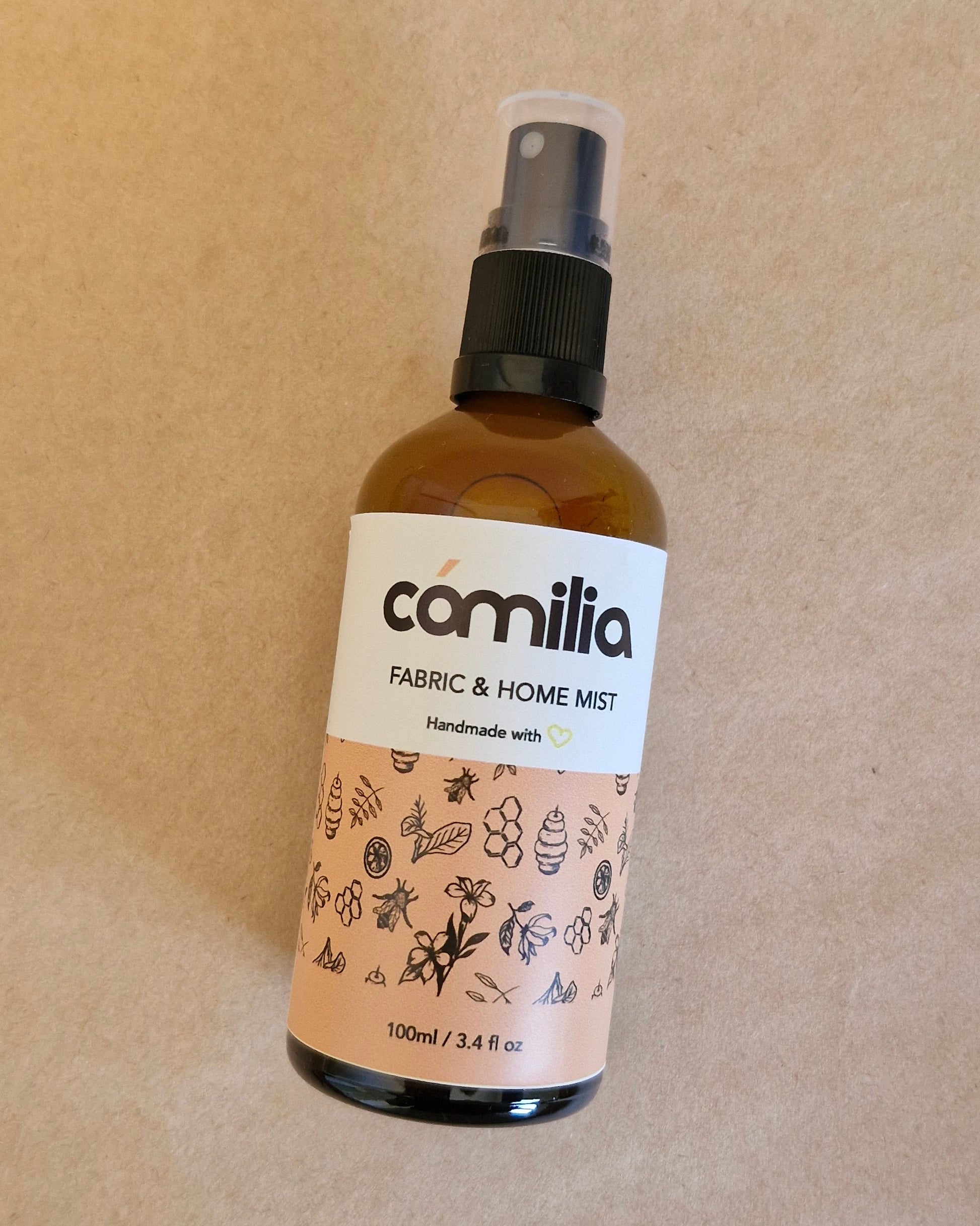 Bottle of Camilia fabric and home mist on a beige background