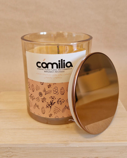 Glass candle with a gold lid on a beige background
