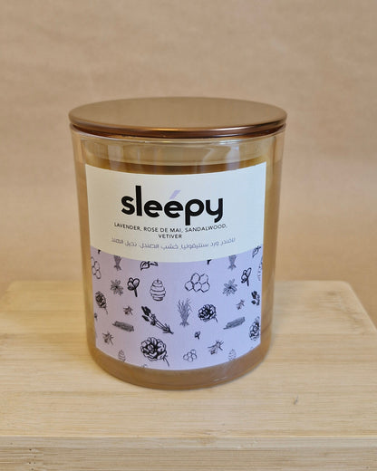Candle labeled 'sleepy' on a wooden surface