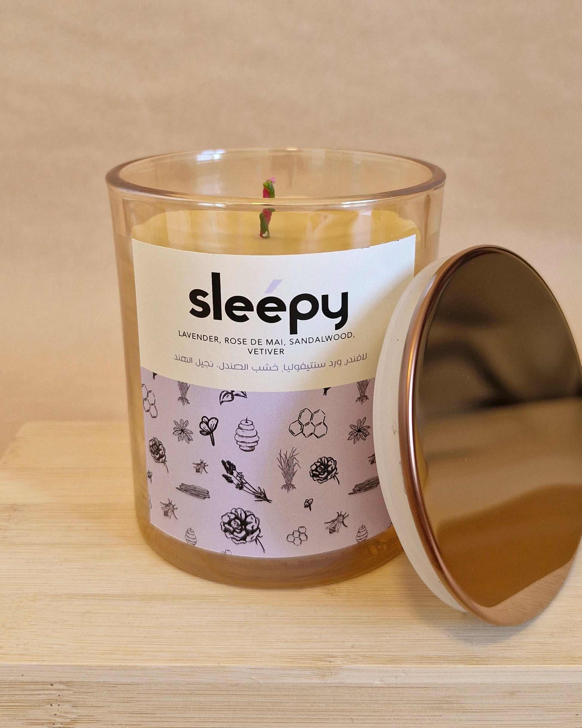 Candle labeled 'sleepy' with a decorative label on a wooden surface
