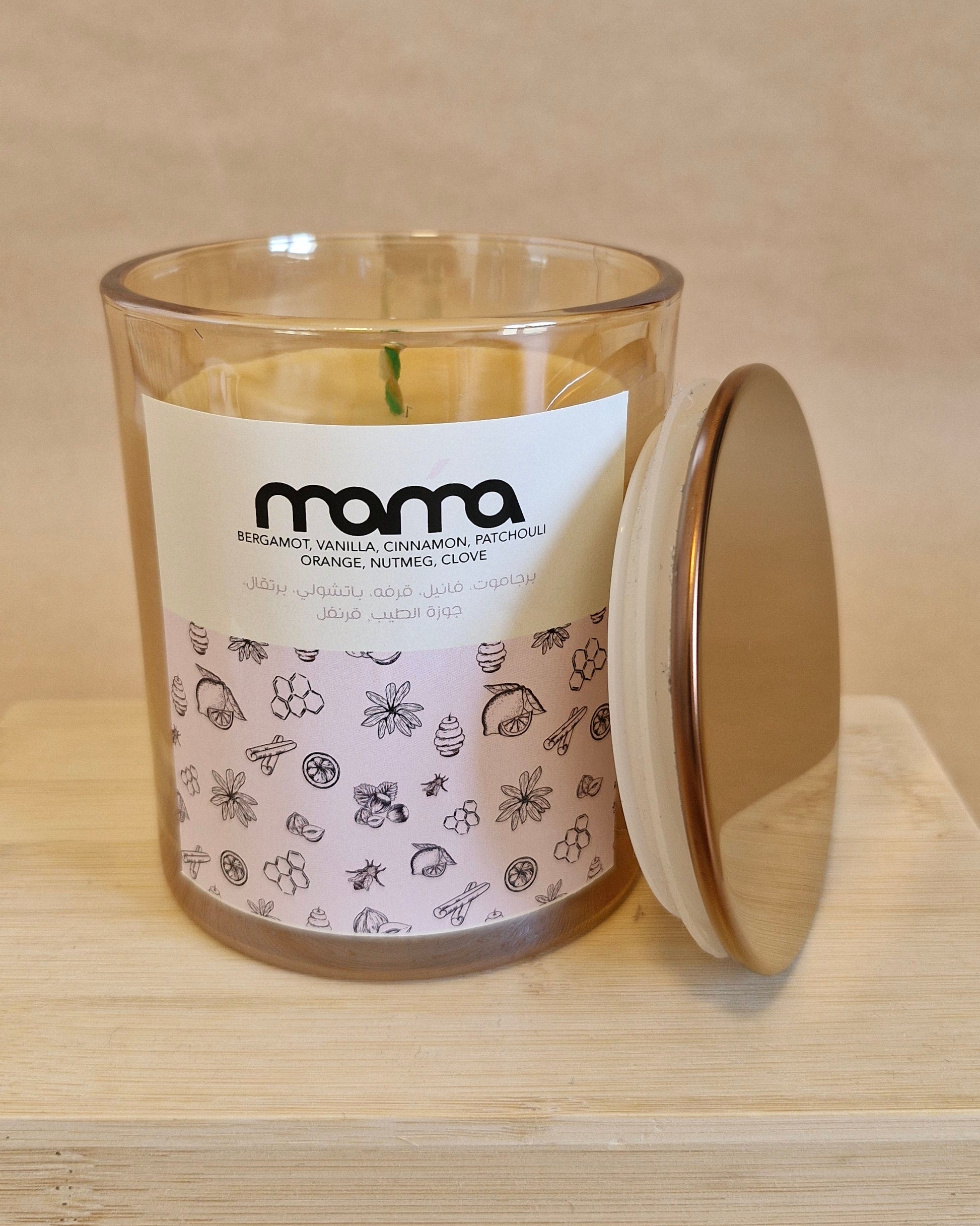 Glass candle with a label on a wooden surface