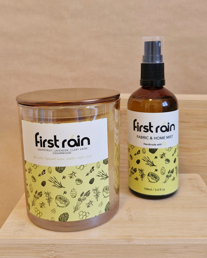 Two bottles of 'First Rain' on a wooden surface
