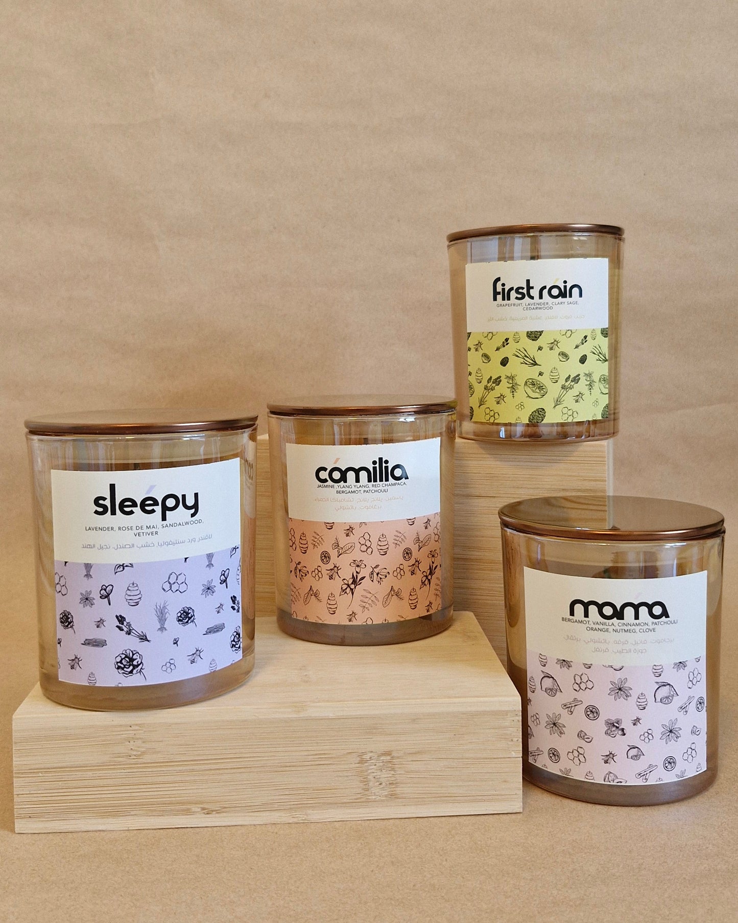 Four candles with labels on a wooden block against a beige background