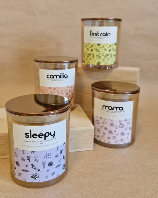 Four candles with labels on a wooden surface