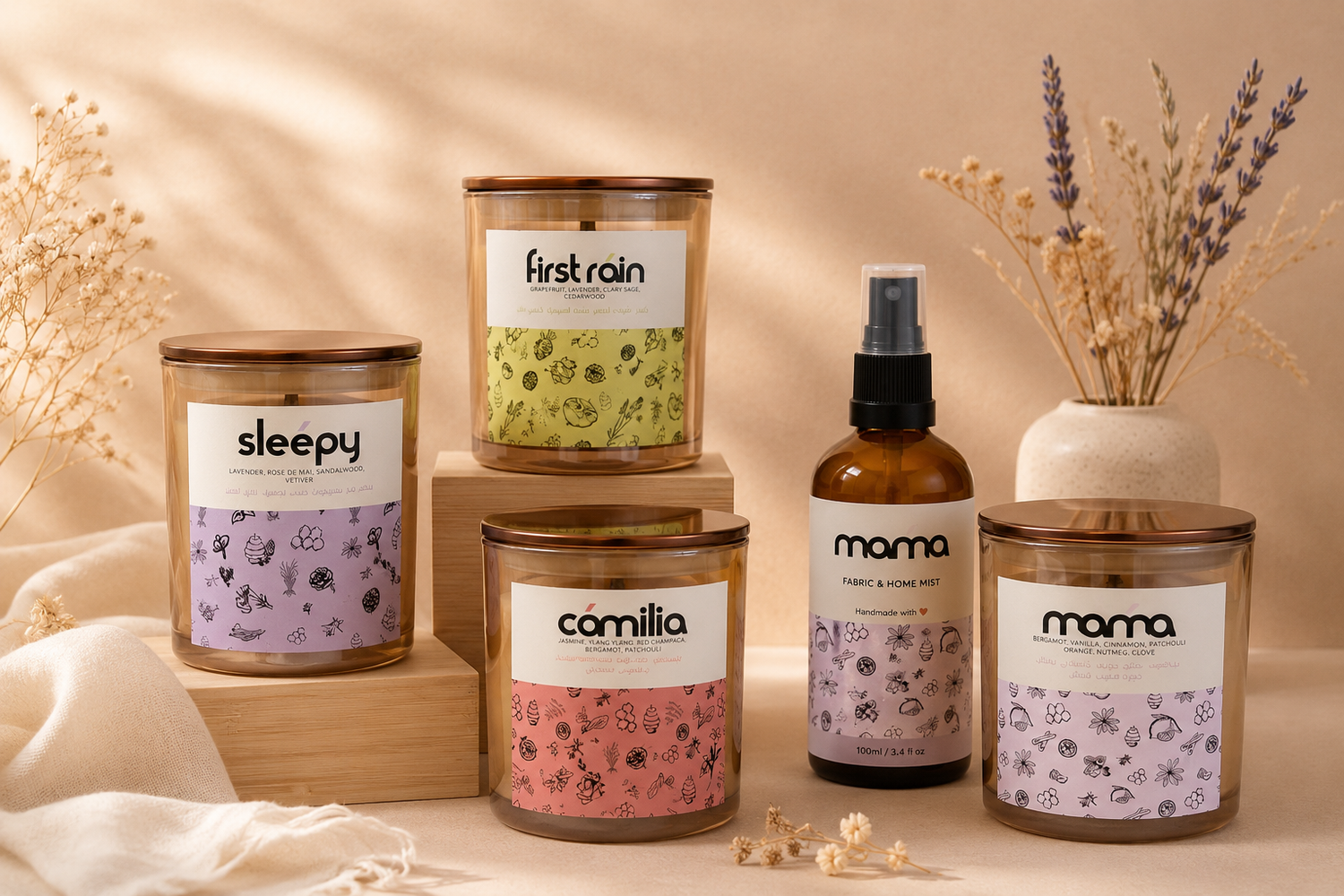 Collection of candles and a bottle of fabric and home mist with labels on a neutral background